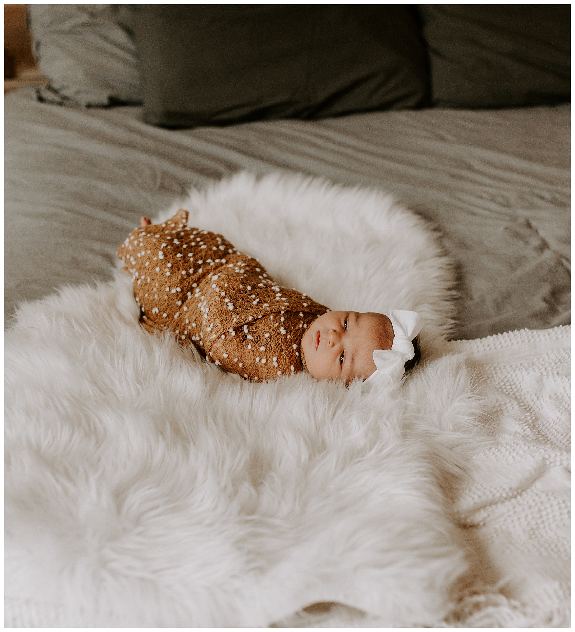 newborn baby on white furry blanket